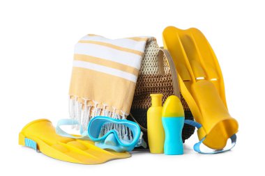 Beyaz arka planda izole edilmiş güneş kremi ve plaj aksesuarlarıyla dolu plaj çantası, yakın plan.