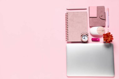 Modern dizüstü bilgisayarlı kompozisyon ve pembe arka planda okul malzemeleri.