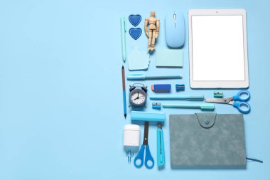 Mavi arka planda modern tablet bilgisayar ve okul malzemeleri ile kompozisyon