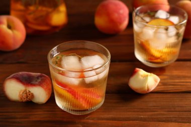 Taze şeftalili limonata ve ahşap arka planda meyveler, yakın plan.