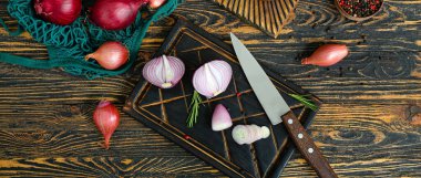 Kahverengi ahşap arka planda farklı soğan çeşitleri olan tahtalar