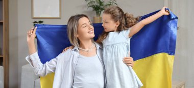 Evde Ukrayna bayrağı taşıyan sevimli küçük bir kız ve annesi var.