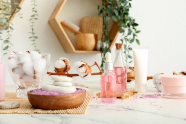 Kozmetik ürünler, banyo malzemeleri ve odadaki ışık masasının üzerindeki pamuk dalı.