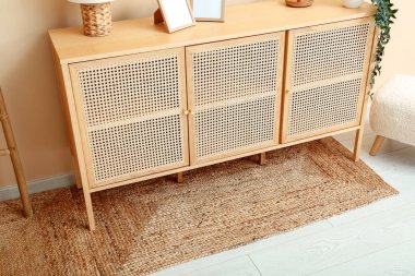 Oturma odasında boş resimler ve hasır halılar olan çekmeceler.