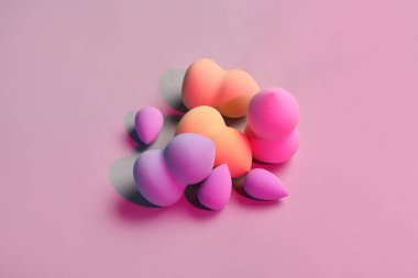 Pembe arka planda farklı makyaj süngerleri