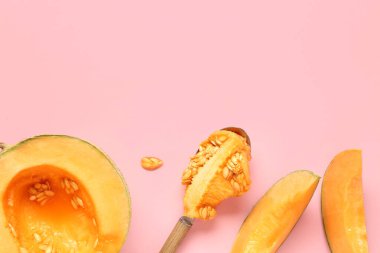 Tatlı kavun ve kaşığı pembe arka planda tohumlarla kes