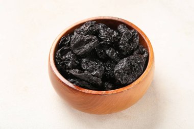 Beyaz zemin üzerine lezzetli kurutulmuş Erik ile kase