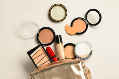 Bej arka planda dekoratif kozmetik ürünleri olan çanta