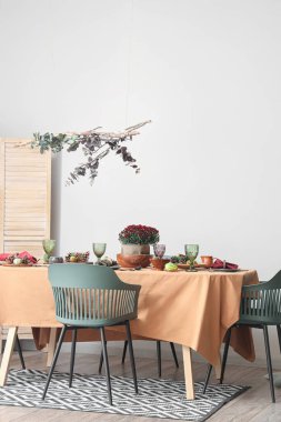 Modern yemek odasında bir buket çiçek ve balkabağı ile güzel bir sonbahar masası.