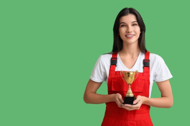 Yeşil arka planda altın bardağı olan kadın işçi.