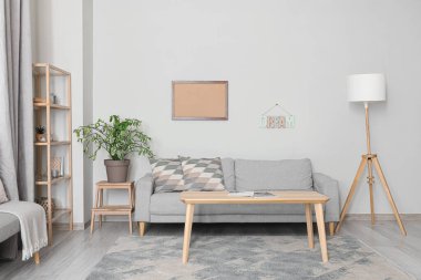 Oturma odası, kanepe ve ışık duvarının yanındaki masa.