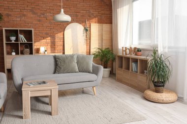 Gri kanepesi ve çiçekleri olan bir çatı katı tarzı oturma odası.