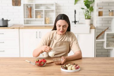 Çikolata kaplı çilek ve taze böğürtlenli güzel bir kadın.