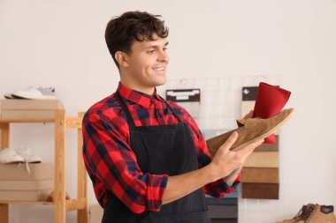 Erkek ayakkabıcı tamircide süet ayakkabı temizliyor.