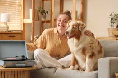 Avustralya çoban köpeği ve pikabı olan genç bir kadın evdeki masada.