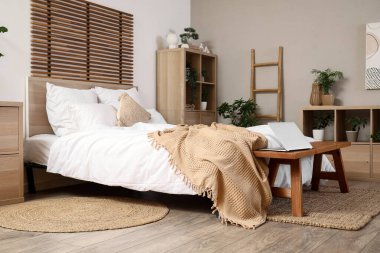 Bankı ve dizüstü bilgisayarı olan şık bir yatak odası.