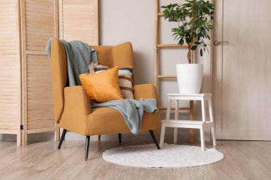 Oturma odasının şık, rahat koltuğu ve ahşap perdesi var.