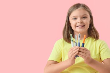 Pembe arka planda tükenmez kalemleri olan şeker hastası bir kız.