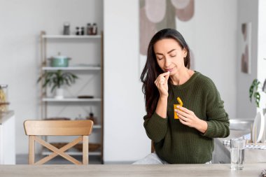 Evde hap alan güzel bir kadın.