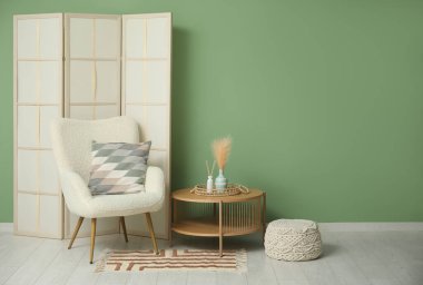 Katlanan ekran, koltuk ve masa ile modern odanın içi