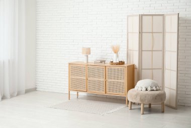 Katlanmış perdeli, puf ve sandıklı modern odanın içi.