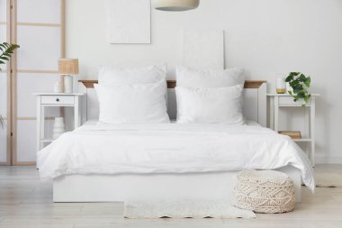 Yatak ve masaların üzerinde beyaz çarşaf olan aydınlatma odasının içinde.