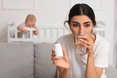 Genç anne doğum sonrası depresyondan muzdarip. Haplar alıyor ve bebeği beşiğinde, yakın plan.