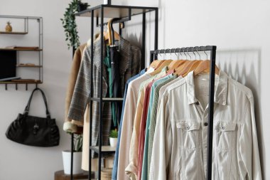 Aydınlık odada şık kıyafetlerle dizilin.