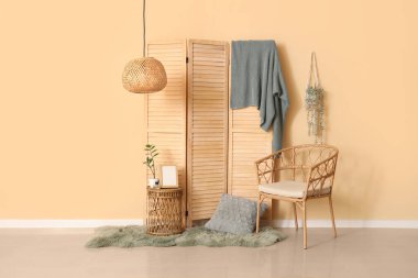 Koltuğu, masası ve ahşap perdesi olan şık bir oturma odası.