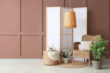 Hasır koltuklu, çiçekli ve beyaz perdeli şık bir oda.