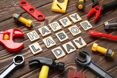 Oyuncak inşaat aletleri ve kelimeler ahşap zeminde mutlu LABOR Günü. İşçi Bayramı kutlamaları