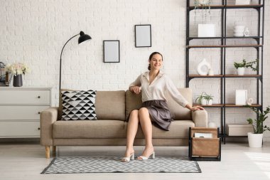 İşten sonra evdeki kanepede dinlenen genç bir kadın.