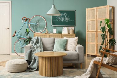 Tahtası, bisikleti ve kanepesi olan bir oturma odası.