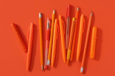 Turuncu arka planda kalemli kalemler