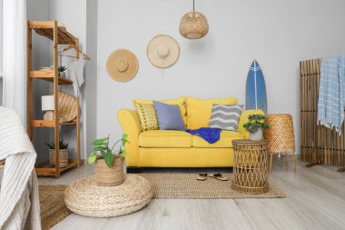 Mayoları, raf ünitesi ve kanepesi olan oturma odasının içinde.