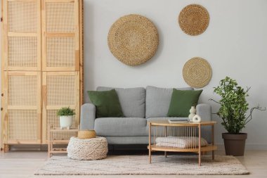 Odanın içinde ahşap dolap, masa ve kanepe var.