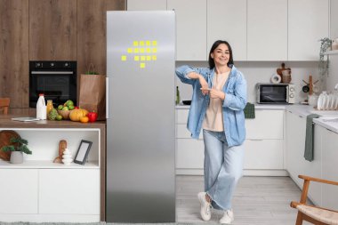 Mutfakta buzdolabının yanında güzel bir kadın.