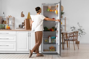 Mutfakta yastık açan genç bir kadın.