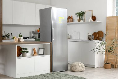 Açık buzdolabı, masa ve ürünleri olan mutfağın içi.