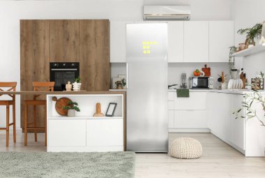 Açık buzdolabı, masa ve ürünleri olan mutfağın içi.