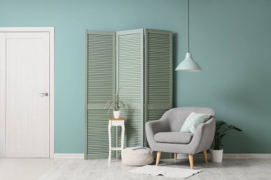 Gri koltuklu, yeşil perdeli ve masalı oturma odasının içi.