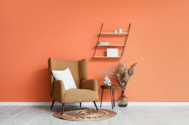 Şık bir oturma odası. Koltuğu, masası ve otları var.