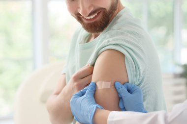 Klinikte aşının ardından doktordan tıbbi yama alan genç adam, yakın plan