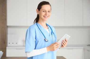 Klinikte tablet bilgisayarı olan bir kadın stajyer.