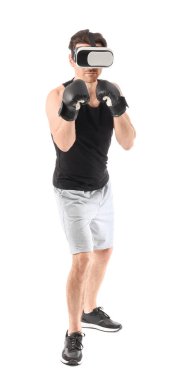 Beyaz arka planda boks eldivenli, VR gözlüklü genç bir adam.