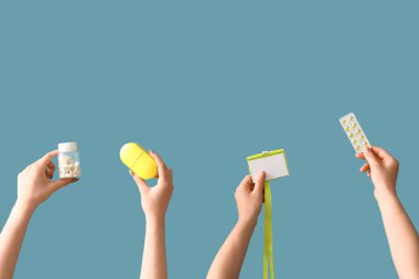 Mavi arka planda hapları ve rozeti olan kadınlar