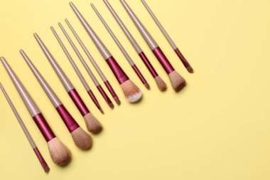 Sarı arkaplanda makyaj fırçaları