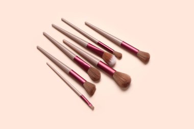 Pembe arka planda farklı makyaj fırçaları