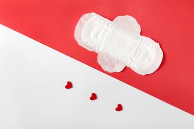 Renkli arka planda kırmızı kalpleri olan adet yastığı.