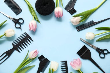Mavi arka planda güzel laleleri olan kuaför aletlerinden yapılmış çerçeve